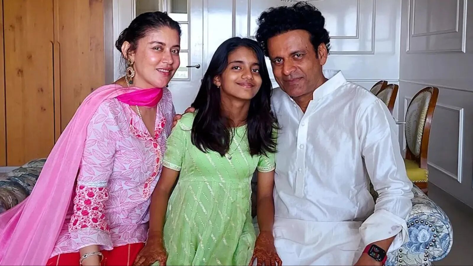 Ava Nayla seated at home between her mother Neha and her father Manoj Bajpayee during a family celebration.