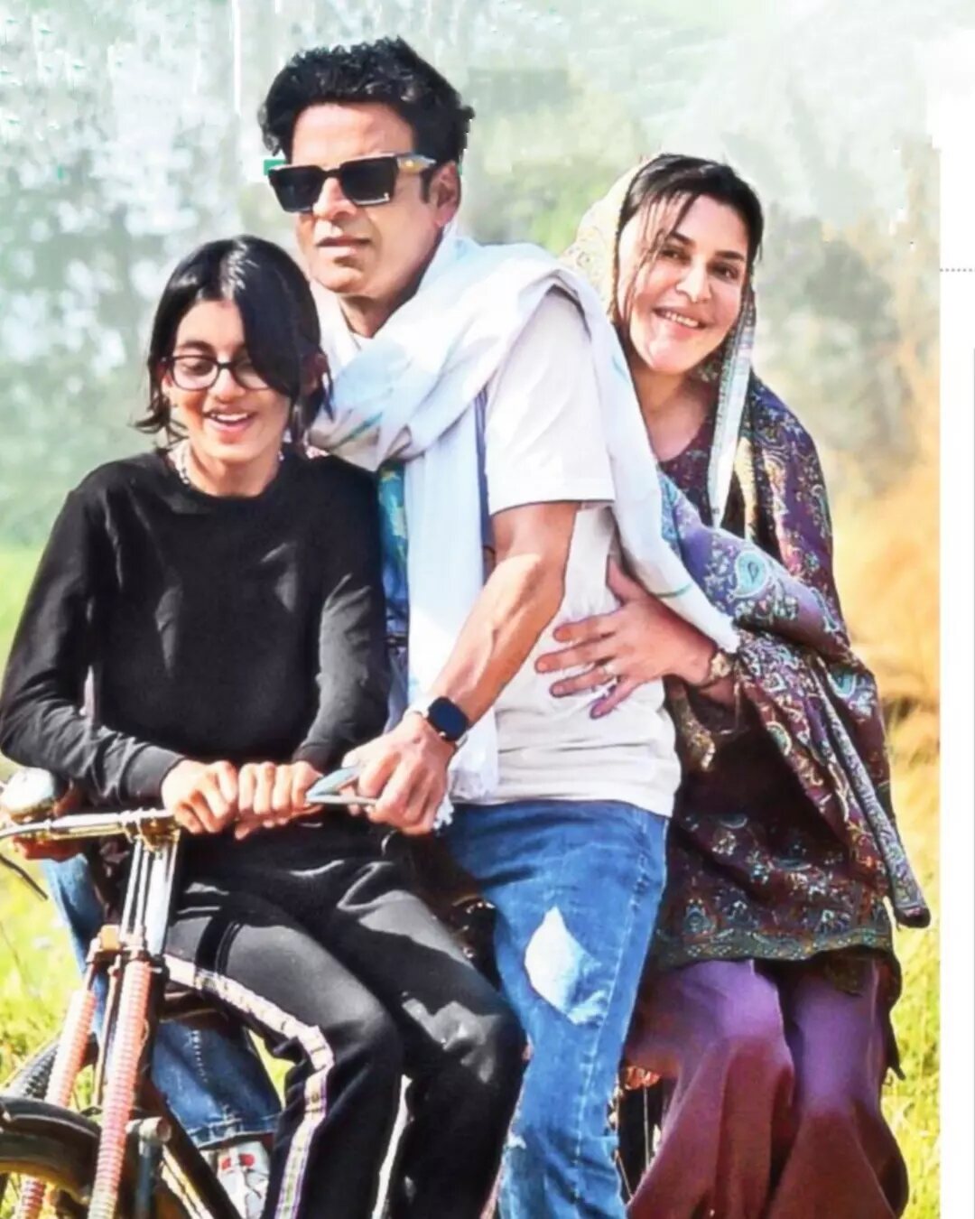 Ava Nayla on a bicycle beside her parents, actor Manoj Bajpayee and Neha, during a family outing in the countryside.